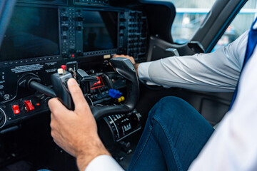 Naklejka premium Pilot operating flight controls in private aircraft cockpit