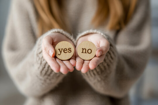 Person holding wooden tokens with yes and no choices symbolizing decision-making and the process of weighing options in uncertain situations indoors