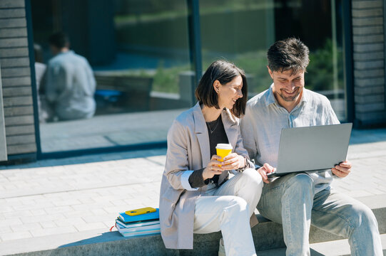 Colleagues working on laptop outside city office building