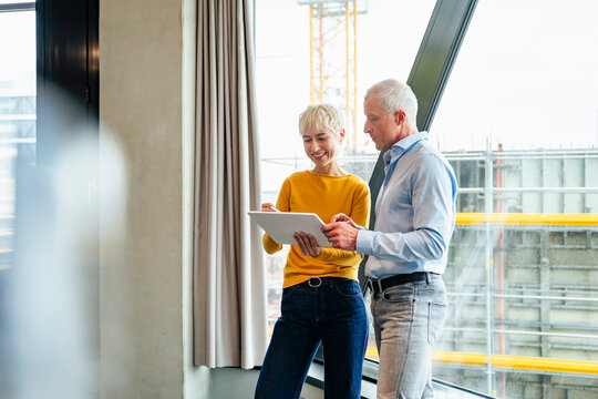 Colleagues discussing project on tablet in office