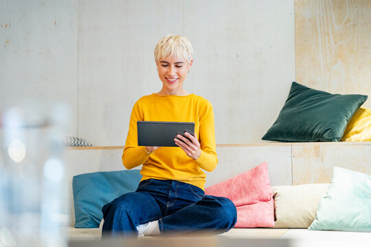 Smiling freelancer using tablet in modern office