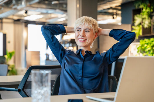 Businesswoman relaxing at desk in modern office