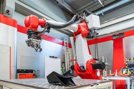Red industrial robotic arm on a production line in a modern factory