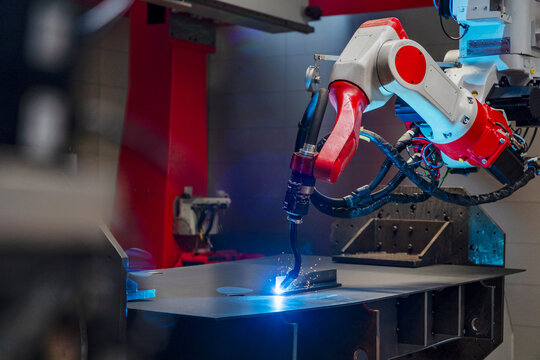 Industrial robot welding metal in modern production factory