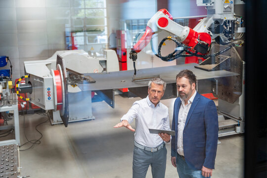 Manager and engineer discussing production in factory