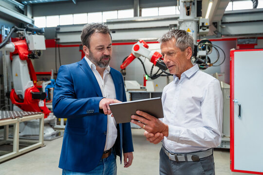 Manager and engineer planning with tablet in factory
