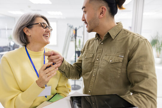 Smiling factory worker talking with colleague at the office
