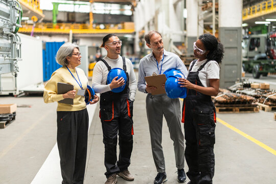 Engineers and technicians discussing in an industrial factory