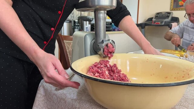 Chef Hands Grinding Meat with Manual Meat Grinder in Home Kitchen