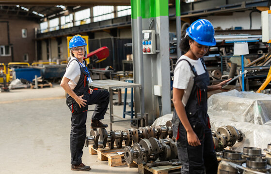 Supervisor and worker checking equipment on factory shift