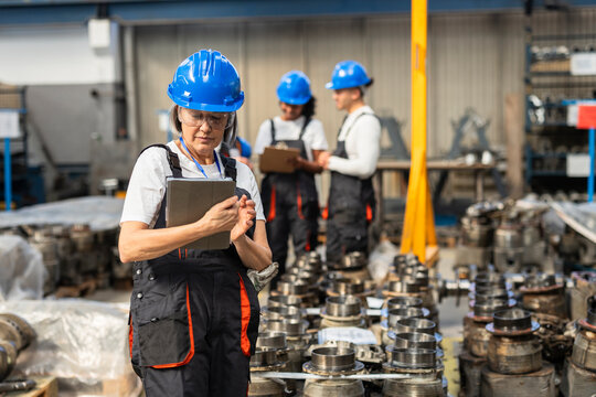 Supervisor using digital tablet in manufacturing factory