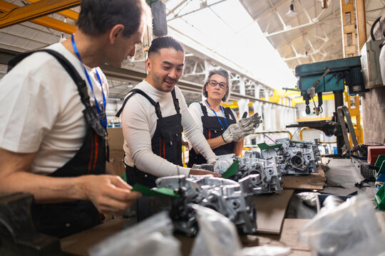 Factory workers assemble engine parts during a maintenance shift