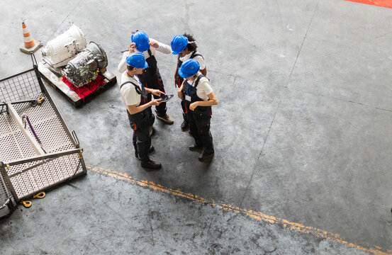 Engineers and supervisor discussing shift maintenance in factory