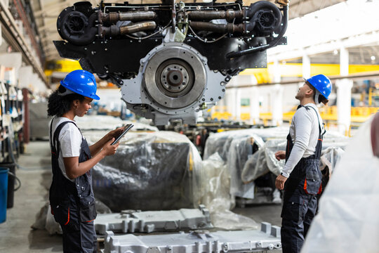 Supervisor inspecting machinery indoors during a work shift