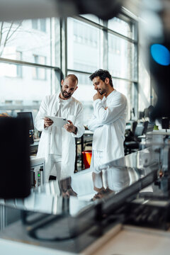 Research team evaluating medical data on tablet in laboratory