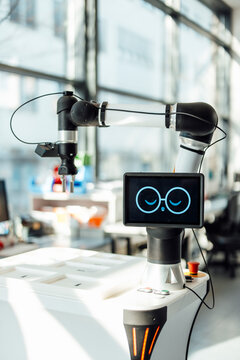 Medical research robot with digital face in laboratory