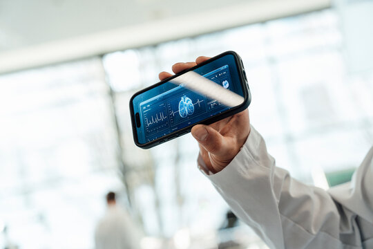 Doctor holding smartphone with digital lung application in laboratory