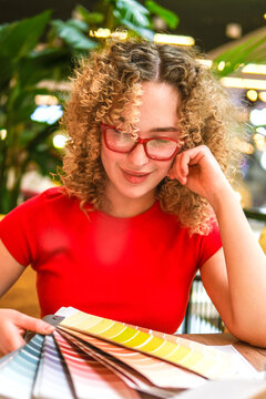Interior designer choosing color swatch in biophilic workspace