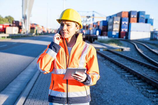 Woman logistics worker on smartphone at commercial dock