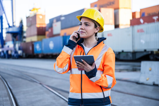 Woman logistics worker calling on mobile at container port