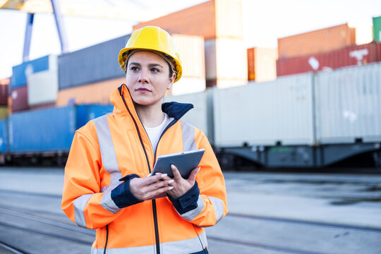 Port engineer inspecting cargo with tablet outdoors
