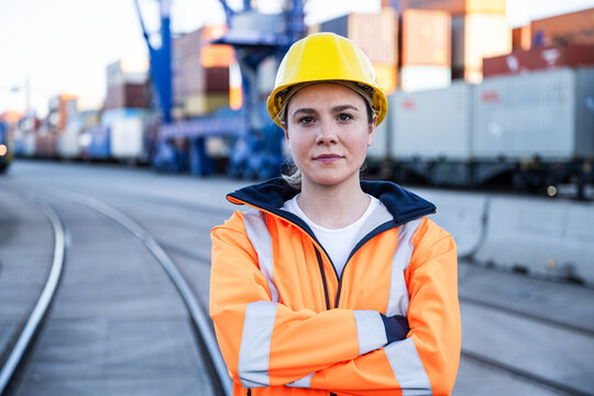 Confident worker in safety helmet at cargo shipping port