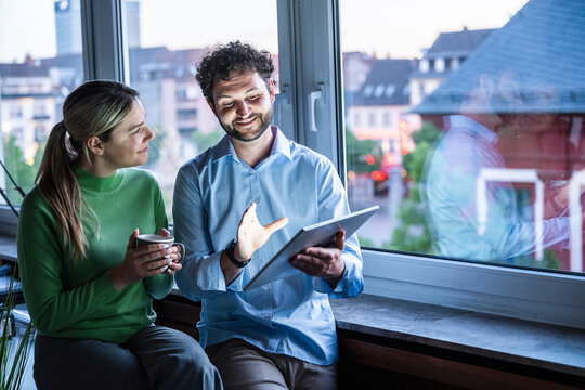 Colleagues discuss business strategy on a tablet in the office