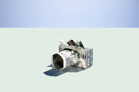 Origami camera folded from a US dollar banknote on white background
