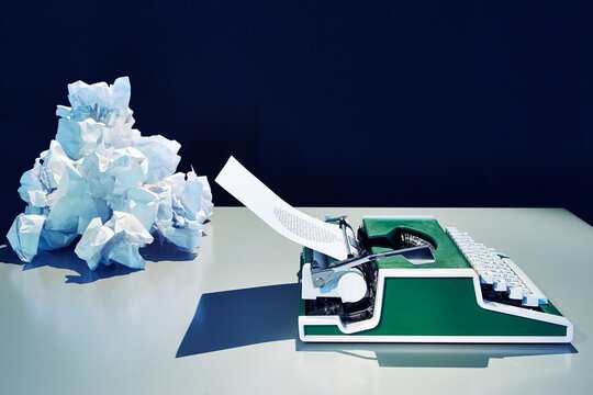 Retro typewriter indoors with crumpled paper and speech bubble