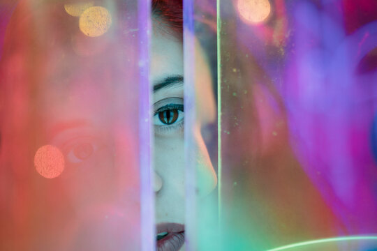 Abstract portrait of partial face looking through neon glass