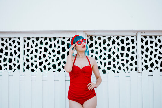 Model in red swimsuit poses outdoors in summer