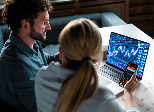 People analyzing financial data on notebook and mobile in office