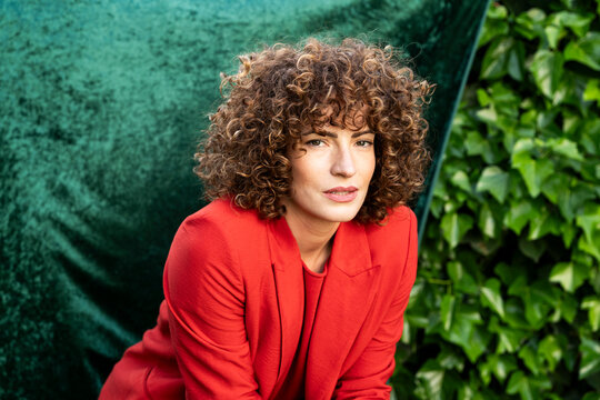 Confident model in blazer posing outdoors in a Granada garden