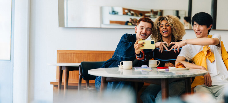 Friends taking a selfie together in a cafe