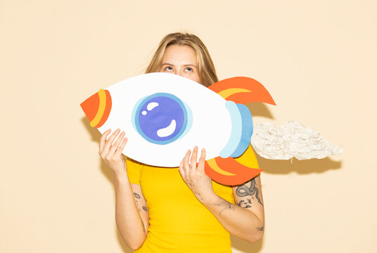 Entrepreneur holding handmade paper rocket symbolizing success