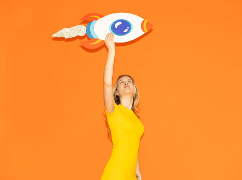 Entrepreneur holding paper rocket for success and ambition