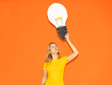 Holding paper light bulb representing creativity and bright idea