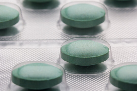 Comprimidos verdes en bl&iacute;ster farmac&eacute;utico, concepto de medicina y tratamiento