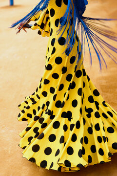Yellow polka dot flamenco dress spinning at Sevilla fair outdoors