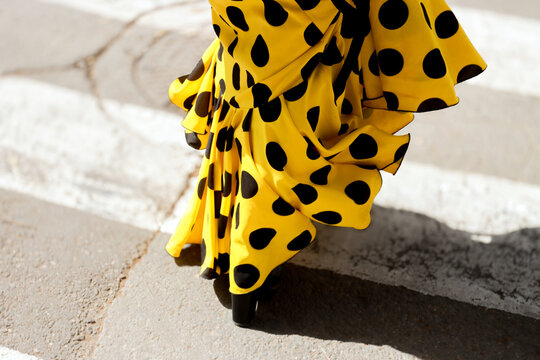 Yellow flamenco dress with polka dot in motion on crosswalk