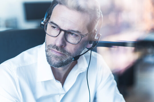 Thoughtful businessman with headset working in the office