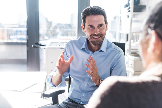 Manager explaining strategy to colleague at the office desk