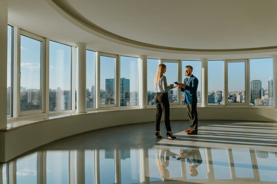 Business colleagues discuss strategy in modern empty office