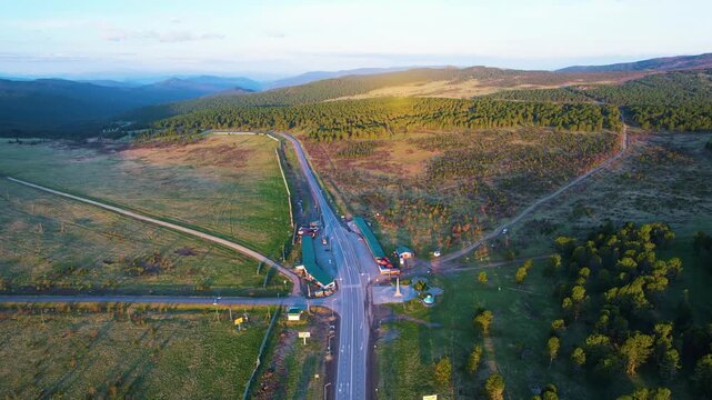 Aerial view of winding forest road at golden hour intersection
