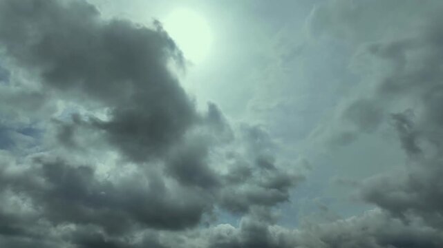 timelapse of a changing sky with evolving stratocumulus clouds drifted by the wind in a blue sky and a veiled sun shining above