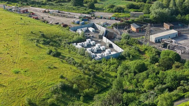 Retreating Aerial of Small BESS Battery Energy Storage System with Modular Lithium-ion Containers. Smart grid management, AI energy optimization and sustainable infrastructure. Filmed in UK. 4K.