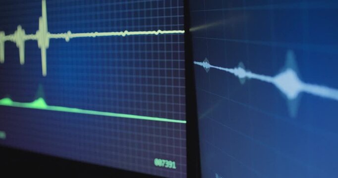 Close up on desktop screen monitors with audio waveform of recorded sound playing. Music production or podcast studio live music conversation. Wiretap of hacker spy agency of criminal cyber activity