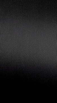 Perforated Metal Mesh. Smooth slow movement across extreme close-up of dark perforated metal grid with dramatic side lighting.