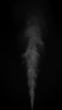 Hot Steam Plume. Slow-motion of hot steam powerfully rising from below, forming a tall turbulent column that expands, gradually dissipates into fine sparkling particles against deep black background.