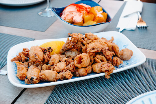 spanish chipirones and patatas bravas on a table